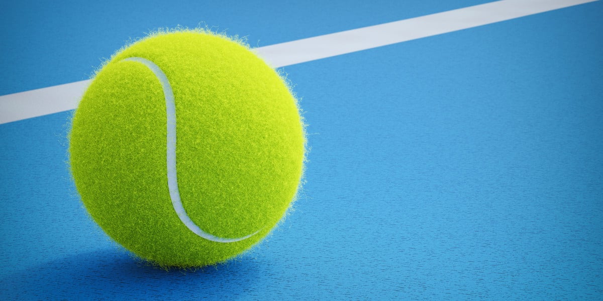 Pelota de padel reposando sobre la cancha azul